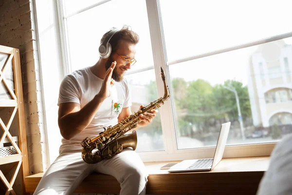 Kaukasischer Musiker spielt Saxofon bei Online-Konzert zu Hause isoliert und unter Quarantäne, beeindruckende Improvisation — Stockfoto