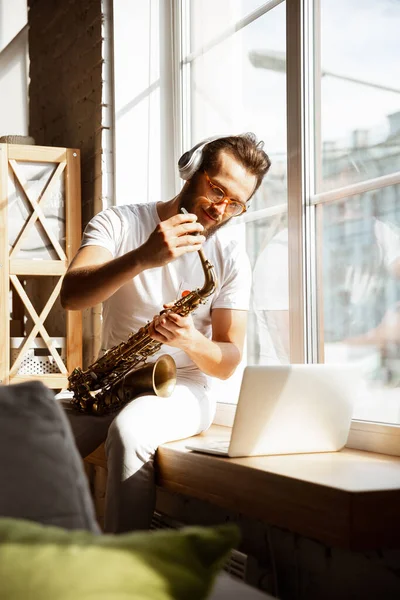 Músico caucásico tocando saxofón durante concierto en línea en casa aislado y en cuarentena, improvisación impresionante — Foto de Stock
