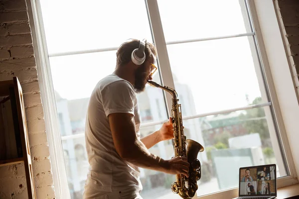 Músico caucásico tocando saxofón durante concierto en línea en casa aislado y en cuarentena, improvisación impresionante — Foto de Stock