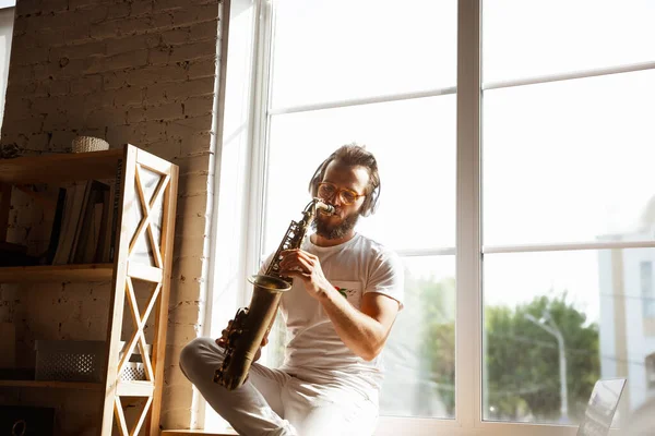 Músico caucásico tocando saxofón durante concierto en línea en casa aislado y en cuarentena, improvisación impresionante — Foto de Stock