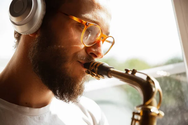 Close up de músico caucasiano tocando saxofone durante concerto em casa isolado e em quarentena — Fotografia de Stock