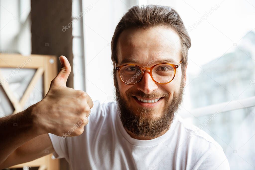 Caucasian musician greeting audience before online concert at home isolated and quarantined, cheerful, smiling