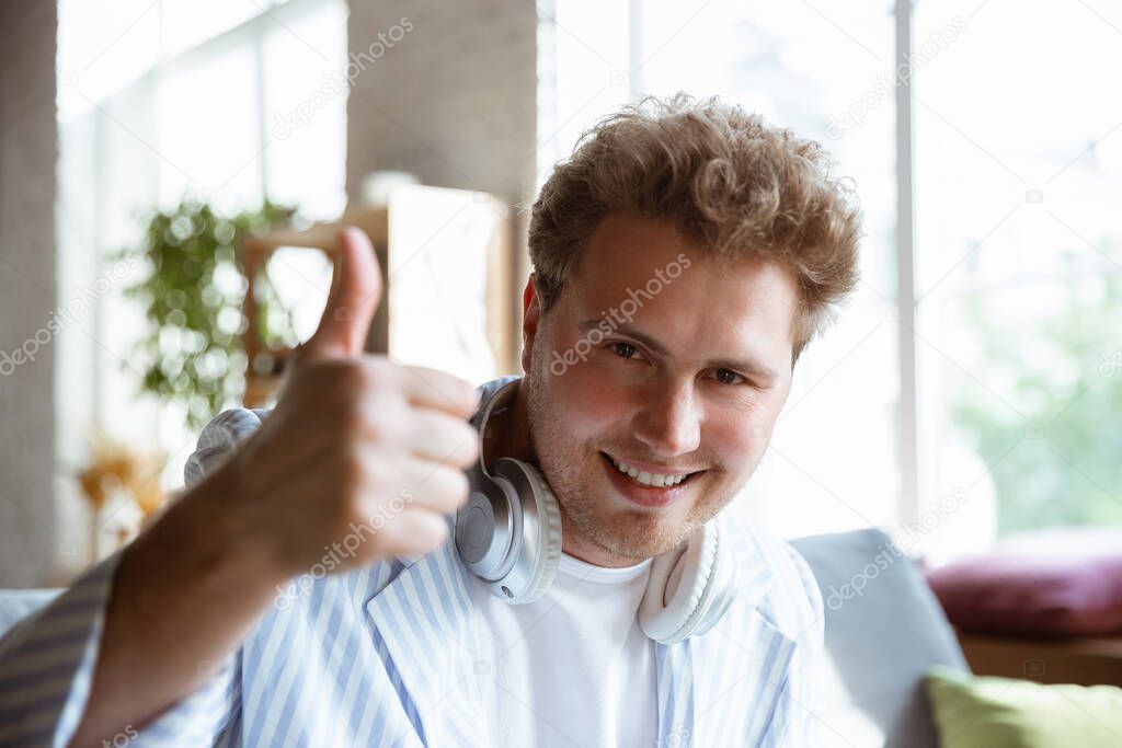Caucasian musician greeting audience before online concert at home isolated and quarantined, cheerful, smiling