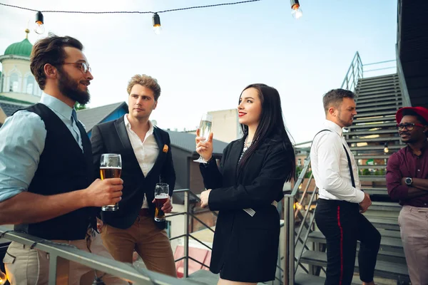 Grupo de jóvenes caucásicos celebrando, se ven felices, tienen fiesta corporativa en la oficina o bar — Foto de Stock