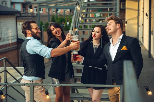 Groupe de jeunes caucasiens célébrant, regarder heureux, avoir une fête d'entreprise au bureau ou au bar — Photo