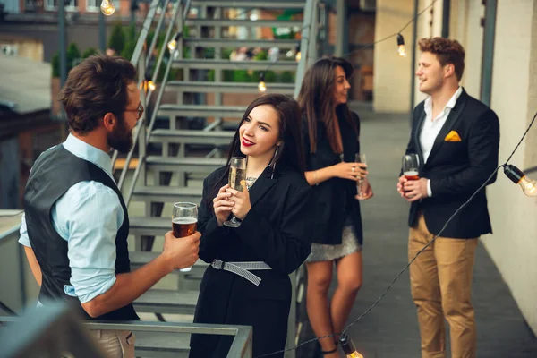 Grupo de jóvenes caucásicos celebrando, se ven felices, tienen fiesta corporativa en la oficina o bar — Foto de Stock