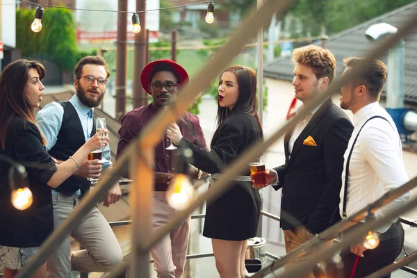 Мультиэтническая группа людей, празднующих, выглядеть счастливыми, иметь корпоративную вечеринку в офисе или баре — стоковое фото