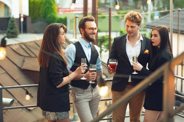 Groupe de jeunes caucasiens célébrant, regarder heureux, avoir une fête d'entreprise au bureau ou au bar — Photo