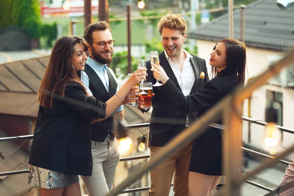 Groupe de jeunes caucasiens célébrant, regarder heureux, avoir une fête d'entreprise au bureau ou au bar — Photo