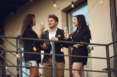 Bir grup Kafkas genci kutlama yapıyor, mutlu görünüyor, ofiste ya da barda kurumsal parti veriyorlar.