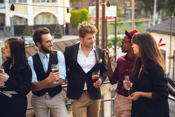 Grupo multiétnico de personas que celebran, se ven felices, tienen fiesta corporativa en la oficina o el bar — Foto de Stock