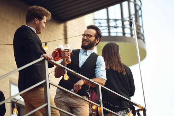 Dos hombres hablando, celebrando, se ven felices, tienen una fiesta corporativa en la oficina o en el bar — Foto de Stock