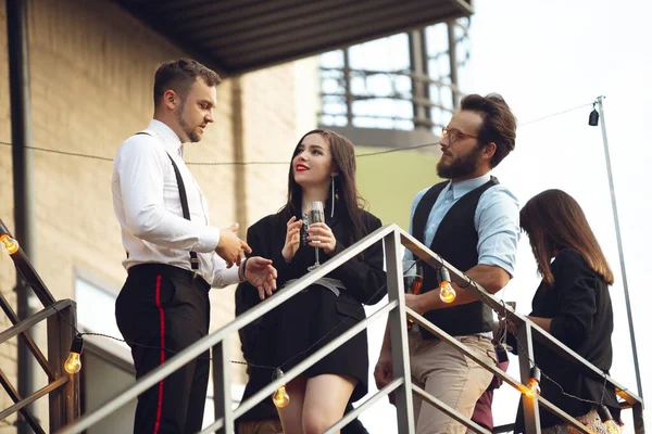 Grupo de jóvenes caucásicos celebrando, se ven felices, tienen fiesta corporativa en la oficina o bar — Foto de Stock