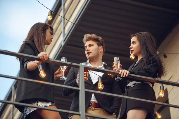 Grupo de jóvenes caucásicos celebrando, se ven felices, tienen fiesta corporativa en la oficina o bar — Foto de Stock