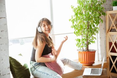 Beyaz kadın şarkıcı, izole edilmiş ve karantinaya alınmış, neşeli ve mutlu bir şekilde canlı performans sergiliyor.