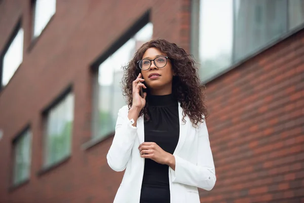 Hermosa mujer de negocios afroamericana bien vestida se ve confiada y ocupada, exitosa —  Fotos de Stock