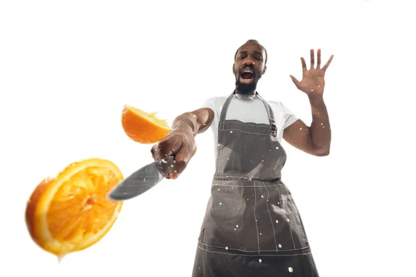 Csodálatos afro-amerikai férfi készít hihetetlen ételek közelről akció, részletek és fényes érzelmek, profi szakács. Narancssárga vágás menet közben — Stock Fotó