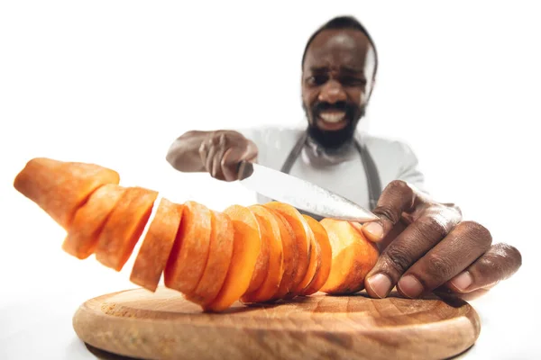 Csodálatos afro-amerikai férfi készít hihetetlen ételek közelről akció, részletek és fényes érzelmek, profi szakács. Sárgarépát vágni menet közben — Stock Fotó