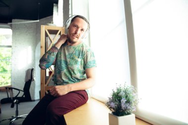 Oturma odasında bir video konferansı sırasında el kol hareketi yapan genç adam. Katılımcı dinleme