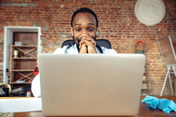 Arzt berät den Patienten online mit Laptop. Afroamerikanischer Arzt während seines Videocalls, arbeitet mit Patienten und erklärt Rezepte für Medikamente. — Stockfoto