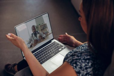 Doktorların semptomları kontrol etmesi ve uyuşturucu alımlarını açıklamasıyla görüntülü görüşme sırasında çevrimiçi tıbbi yardım ve danışmanlık alan genç kadına yakın çekim