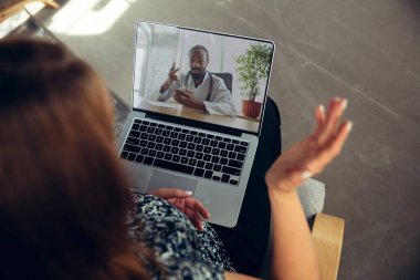 Doktorların semptomları kontrol etmesi ve uyuşturucu alımlarını açıklamasıyla görüntülü görüşme sırasında çevrimiçi tıbbi yardım ve danışmanlık alan genç kadına yakın çekim