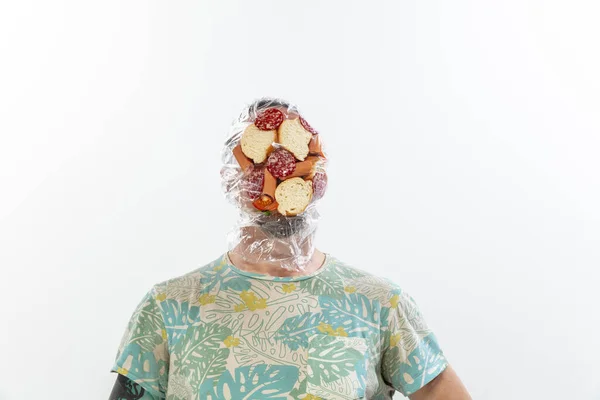 Male face covered with oilcloth, cellophane and unhealthy food, hard to breathe. People lost their faces, cant notice the environmental pollution made by themself. — Stock Photo, Image