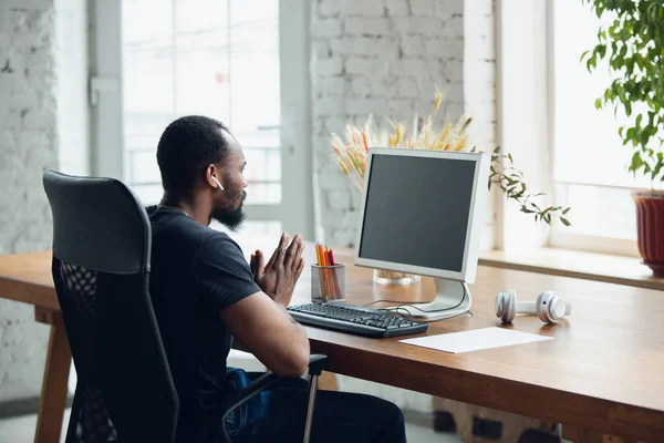 Junger Mann, Geschäftsmann im Büro, Blick auf leeren schwarzen Computerbildschirm, Monitor. Kopierraum. — Stockfoto