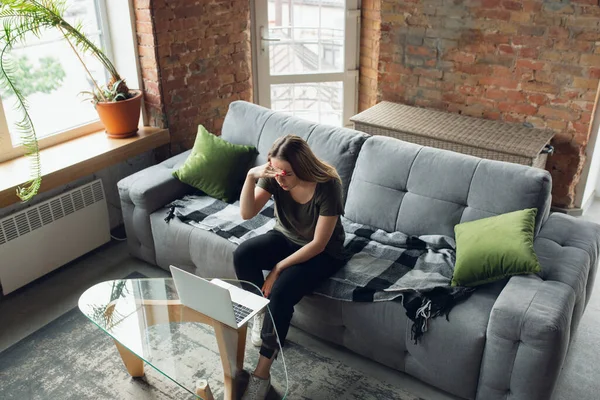 Mujer joven, mujer de negocios trabajando o estudiando en casa, mirando en la pantalla de la computadora, monitor. Atentos, concentrados. Copyspace. Vista superior . — Foto de Stock