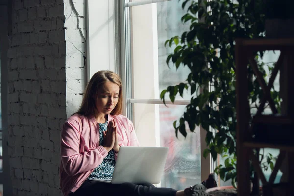Ung kvinna, affärskvinna som arbetar eller studerar hemma med laptop nära fönstret. Attackerad, koncentrerad. Upphovsrätt. — Stockfoto