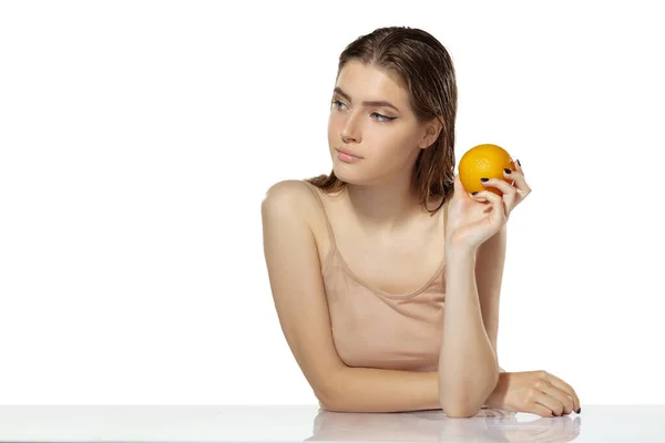 Hautpflege. Schöne junge Frau mit orangefarbenem über weißem Hintergrund. Kosmetik und Make-up, natürliche und ökologische Behandlung. — Stockfoto