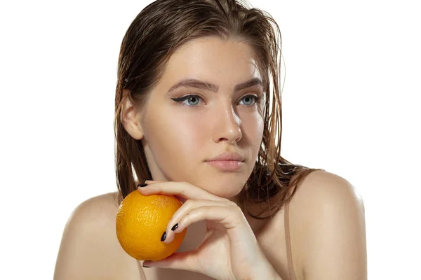 Cuidado com a pele. Mulher bonita com laranja sobre fundo branco. Cosméticos e maquiagem, tratamento natural e ecológico . — Fotografia de Stock