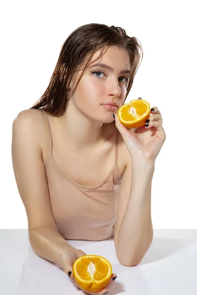 Orgânico. Mulher bonita com fatias de laranja sobre fundo branco. Cosméticos e maquiagem, tratamento natural e ecológico, cuidados com a pele . — Fotografia de Stock