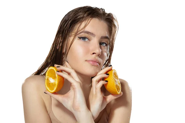 Orgánica. Hermosa joven con rodajas de naranja sobre fondo blanco. Cosméticos y maquillaje, tratamiento natural y ecológico, cuidado de la piel . — Foto de Stock