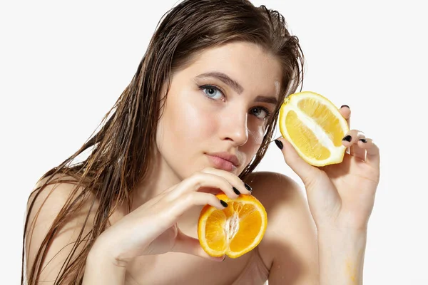 Secrets de jeunesse. Gros plan de belle jeune femme avec des tranches de citron et d'orange sur fond blanc. Cosmétiques et maquillage, traitement naturel et écologique, soin de la peau . — Photo