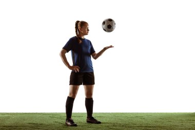 Kadın futbol oyuncusu, beyaz arka planda tek başına top oynarken kendine güvenen bir futbolcu