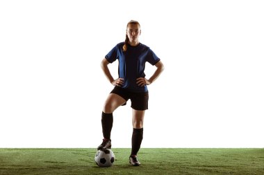 Kadın futbol oyuncusu, beyaz arka planda tek başına top oynarken kendine güvenen bir futbolcu