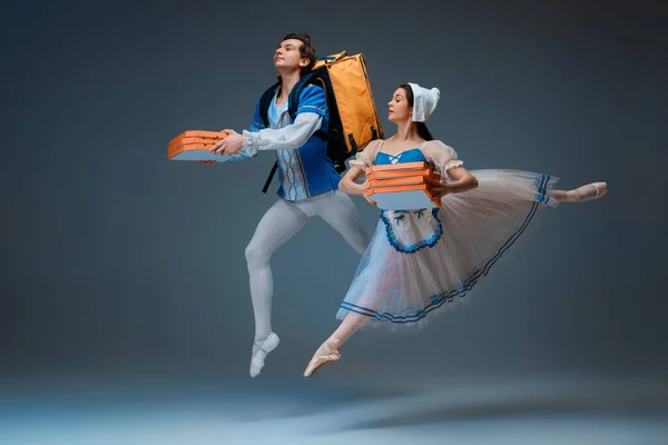 Jovens e graciosos bailarinos de balé como personagens Cinderela fairytail apressando-se com pizza como entregador — Fotografia de Stock