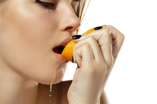 Primer plano de hermosa mujer joven con jugosa naranja sobre fondo blanco. Cosméticos y maquillaje, tratamiento natural y ecológico, cuidado de la piel . — Foto de Stock