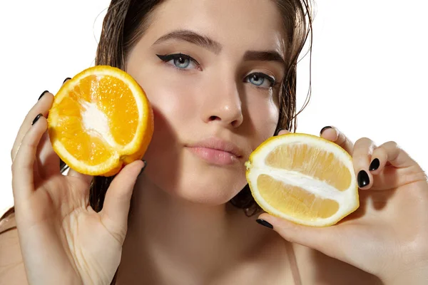 Beyaz arka planda limon ve portakal dilimleri olan güzel genç bayana yakın durun. Kozmetik ve makyaj, doğal ve eko tedavi, cilt bakımı. — Stok fotoğraf
