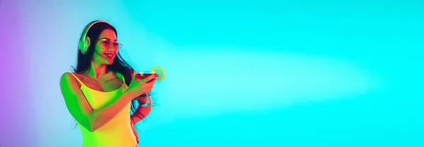 Menina bonita em maiô elegante isolado no fundo do estúdio gradiente em luz de néon. Verão, resort, moda e conceito de fim de semana. Folheto com copyspace . — Fotografia de Stock