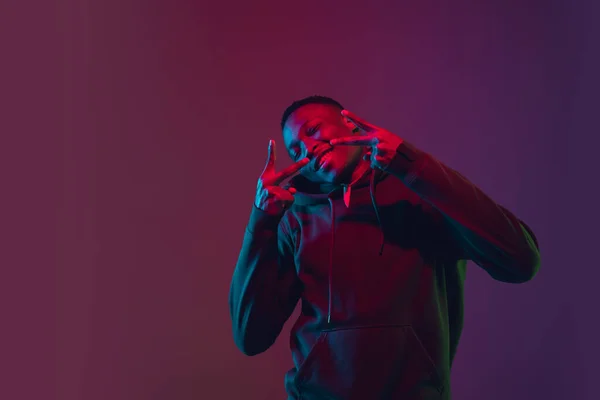 Retrato de hombre afroamericano aislado sobre fondo de estudio degradado en luz de neón —  Fotos de Stock