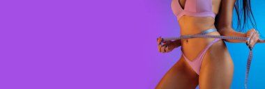 Mor renkli lüks mayo giymiş genç fit ve sportif bir kadının moda portresi. Yaz için mükemmel vücut hazır..