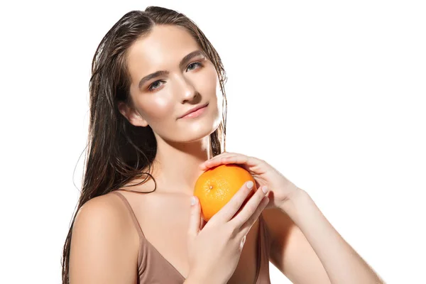 Close up de belo rosto feminino com laranja sobre fundo branco. Cosméticos e maquiagem, tratamento natural e ecológico, cuidados com a pele . — Fotografia de Stock