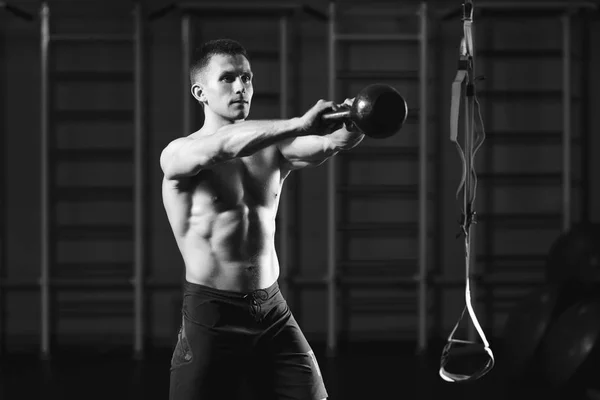 Fitness man doing a weight training by lifting kettlebell — Stock Photo, Image