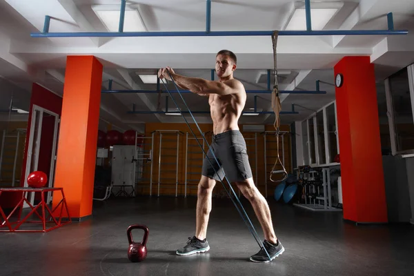 Muž fitness cvičení s protahováním pružná gumička v tělocvičně — Stock fotografie