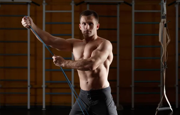 Muž fitness cvičení s protahováním pružná gumička v tělocvičně — Stock fotografie