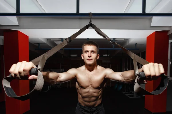 Fitness-Mann trainiert an den Ringen im Fitnessstudio — Stockfoto