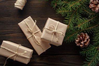 Ahşap arka plan ağaç, çam kozalakları ve karton kutular ile Noel kompozisyonu