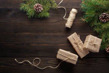 Ahşap arka plan ağaç, çam kozalakları ve karton kutular ile Noel kompozisyonu